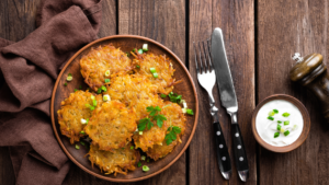 Zdjęcie różnych wariantów placków ziemniaczanych z różnymi dodatkami i sosami.